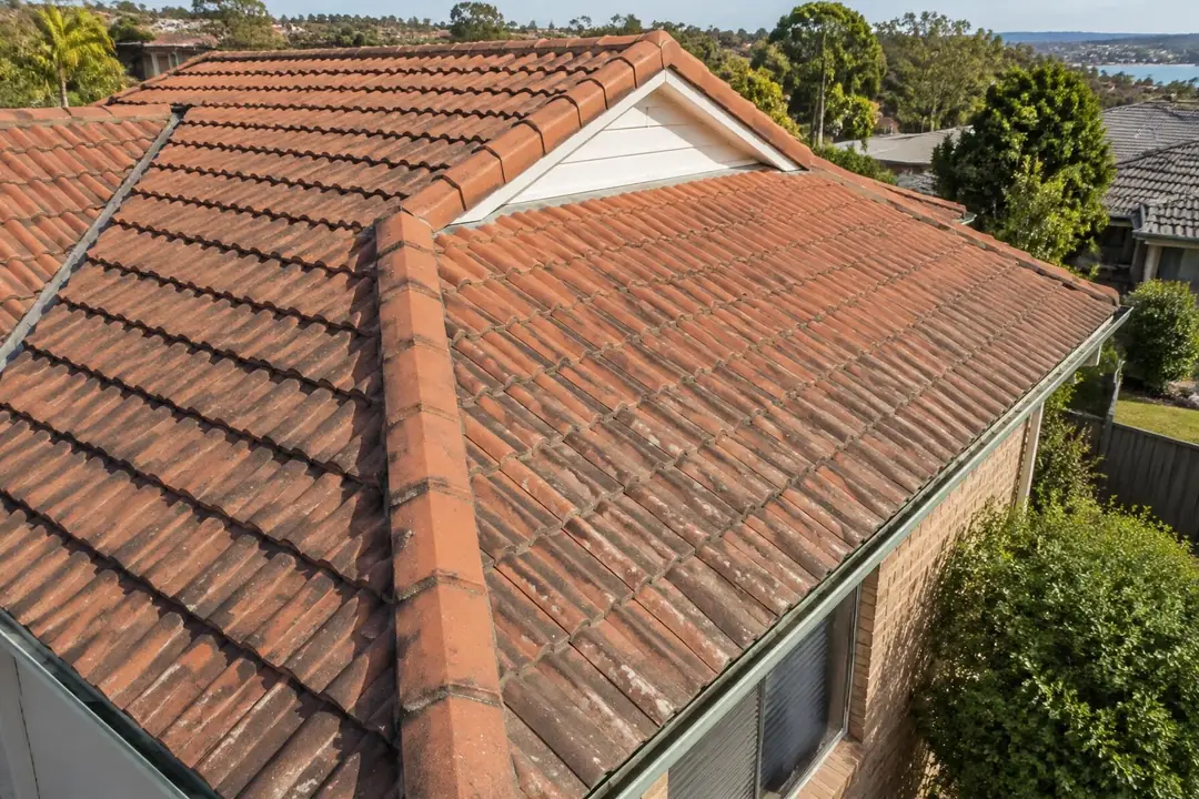 Terracotta tile roof with darker, weathered tiles and a ridge cap
